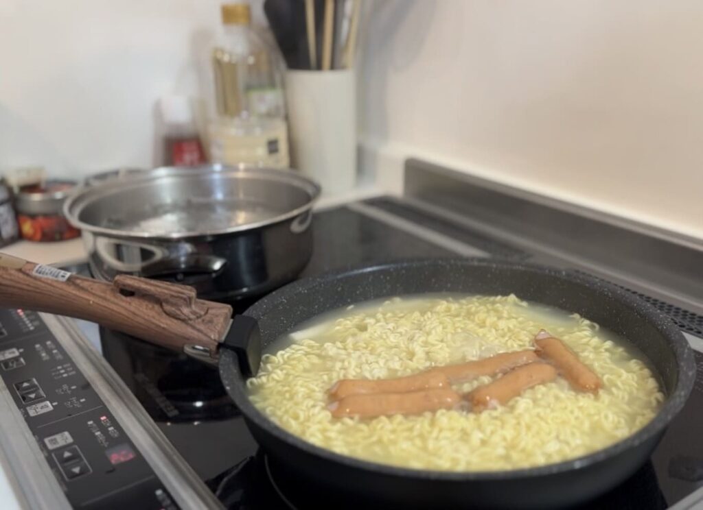 麺とソーセージを茹でます